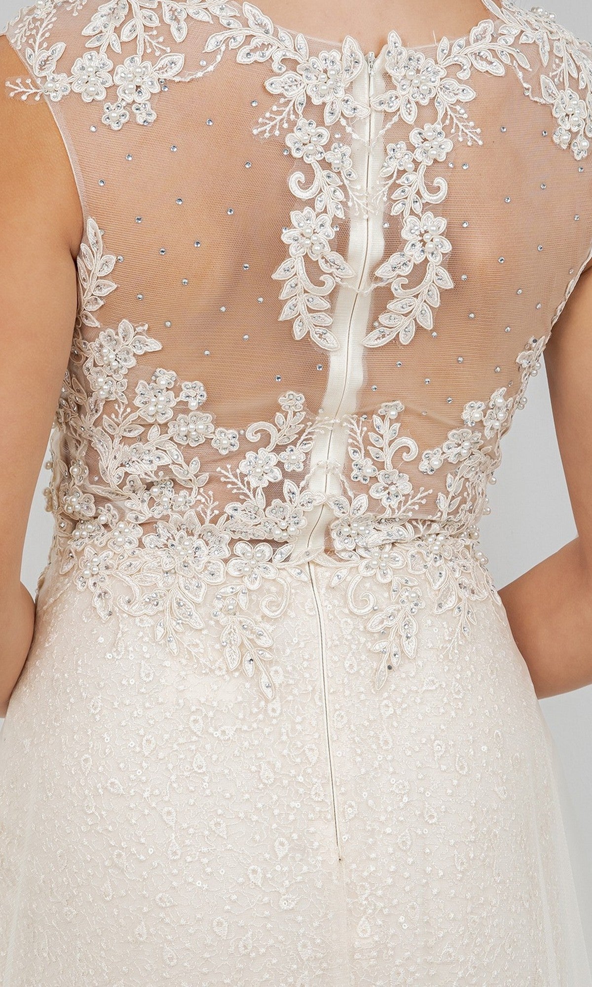 Close-up of the back of the Cinderella Couture 8506J long formal dress, featuring sleeveless ivory design with sheer tulle fabric, bead embellishments, floral embroidery, elegant lace appliques, and a zipper closure.